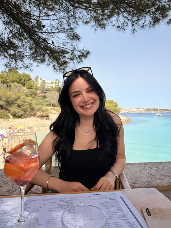 Ines smiling at a seaside café